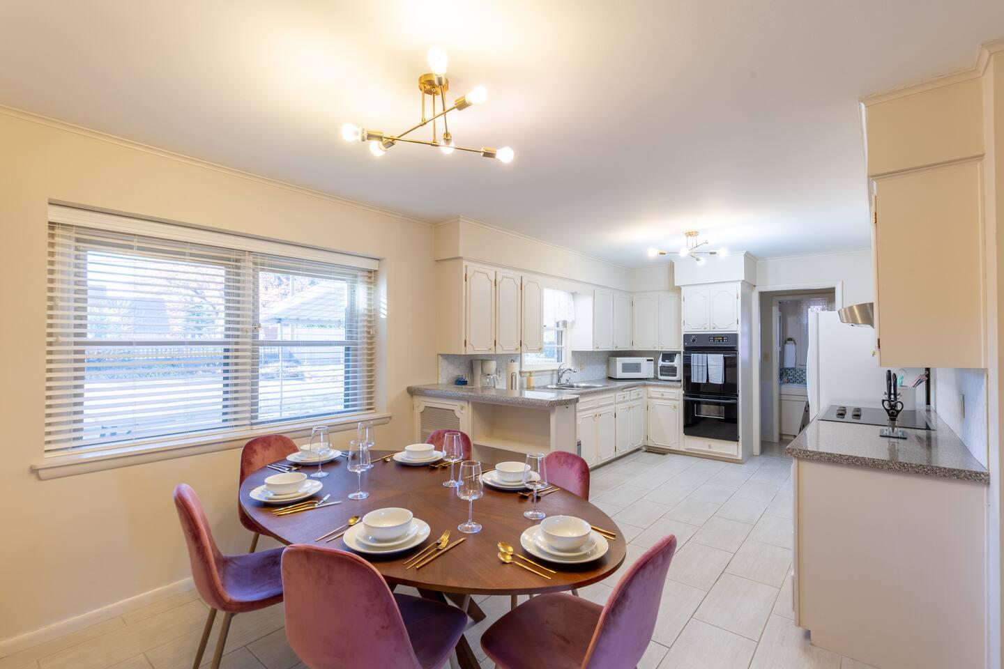 Dining room - Dining table set with plates, silverware and wine glasses for 6. Total of 8 sets of each are available in the cupboards.