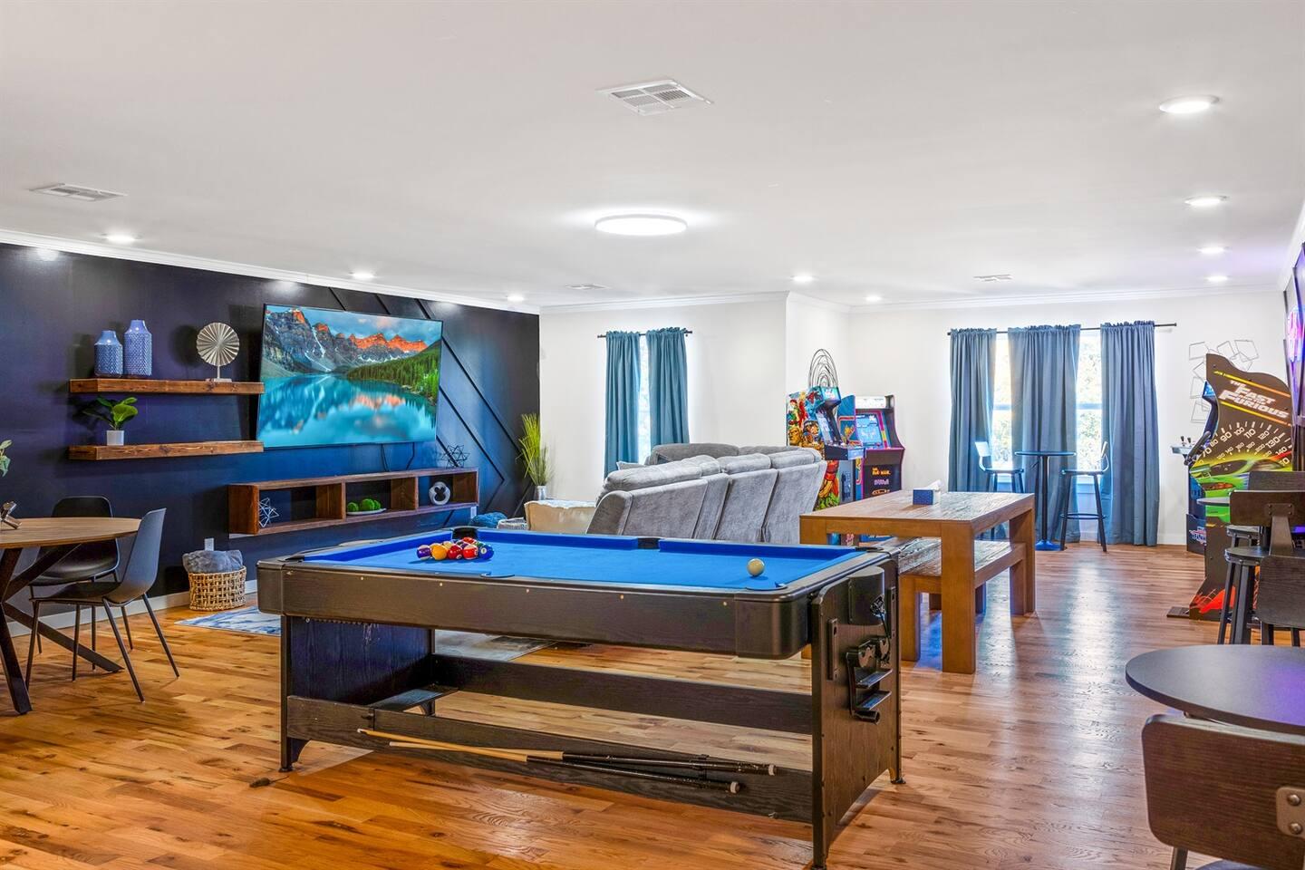 Game room with six arcade machines, pool table and 85-inch TV